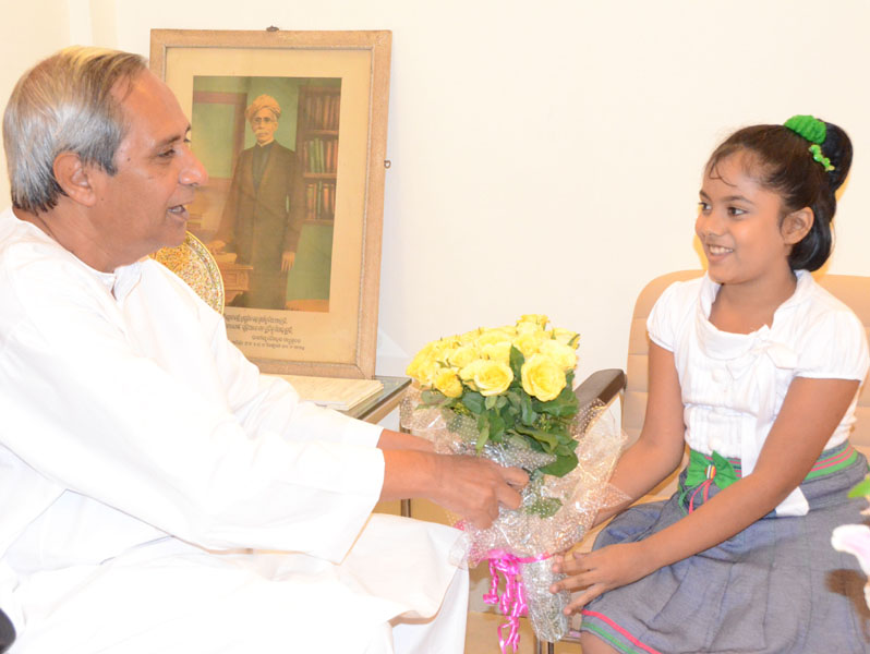 Chief Minister Naveen Patnaik felicitates youngest Odisha Woman Candidate Master Saina Salonika in Bhubaneswar on May 17, 2012.