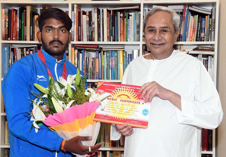 Odisha Chief Minister Naveen Patnaik felicitates Asian kickboxing bronze medallist B Bhaskar Rao with a cheque of Rs 25,000 in Bhubaneswar on June 25, 2018.