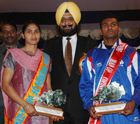 Indian Olympic Association General Secretary Raja Randhir Singh presents the `Strongman` and `Strongwoman` awards to Iswar Machhkund (Right) and Mandakini Mahanta (Left) at the 22nd State Powerlifting Championship in Bhubaneswar on Dec 8, 2008.