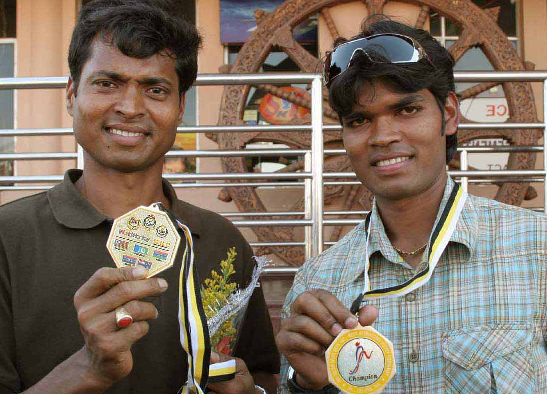 Dilip Tirkey (Left) and Prabodh Tirkey display their Azlan Shah Cup medals on their return home in Bhubaneswar on April 14, 2009.