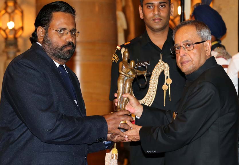 Rowing coach Jose Jacob receives the Dronacharya Award from President Pranab Mukherjee in New Delhi on August 29, 2014.
