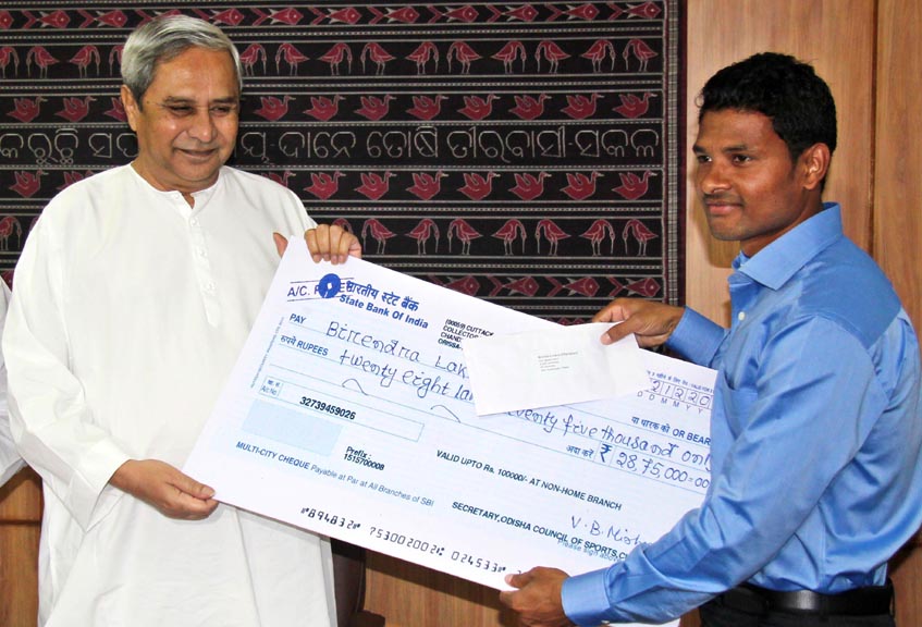 Hockey international Birendra Lakra receives cash award from Chief Minister Naveen Patnaik in Bhubaneswar on December 4, 2014.