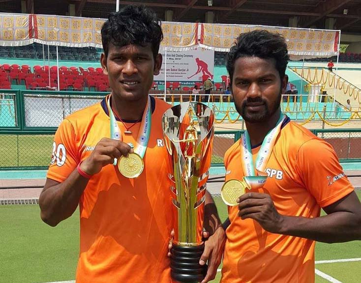 Odisha duo Amit Rohidas and Stanli Victor Minz display the trophy after helping Indian Railways win the title in the 6th Hockey India Senior Men National Championship (Division-A) at Saifai (UP) on May 1, 2016.