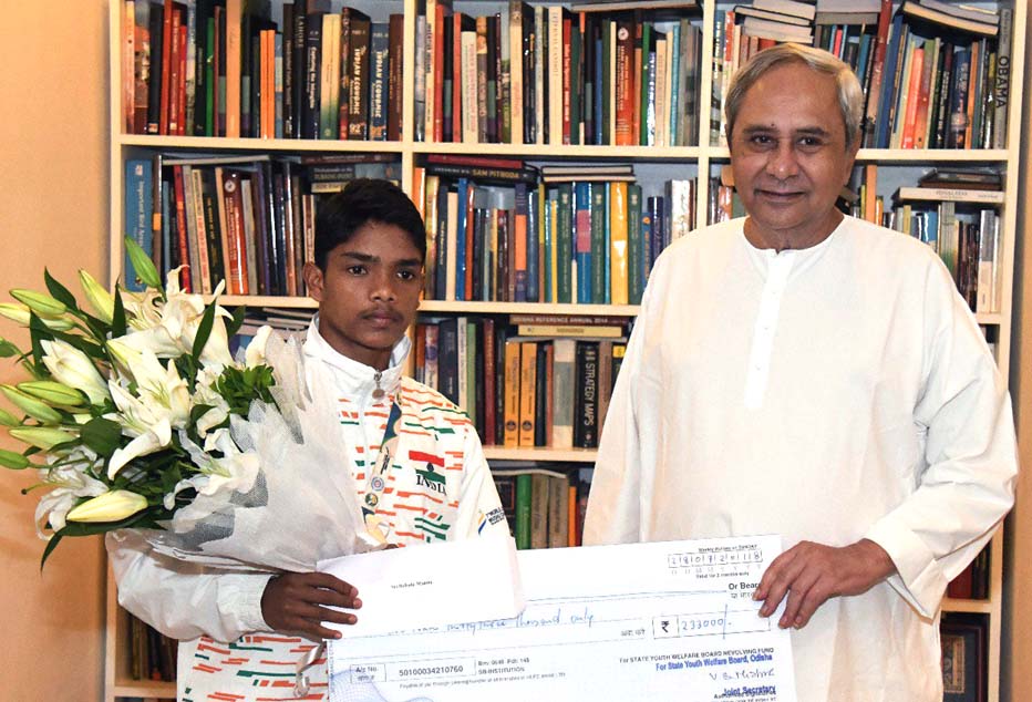 Chief Minister Naveen Patnaik presents Wushu World Junior silver medallist Babulu Munda with a cheque of Rs 2.33 lakhs in Bhubaneswar on July 30, 2018. 